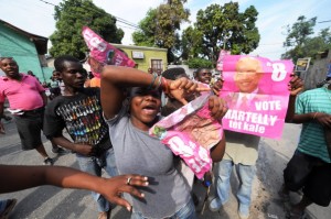 A group of protesters carry posters of Michel Martelly as they parade on the street in Pettion Ville, Haiti