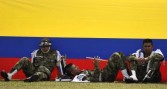 Colombian soldiers rest before a military ceremony