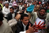 Yemeni anti-government protesters carry away a wounded demonstrator in Sanaa, March 18 2011
