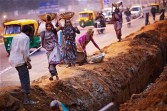 Indian women work at a construction project in front of the Jawaharlal Nehru Stadium on February 01, 2010 in New Delhi, India.