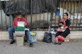 typewriting a professional typist (L) preparing a document for a client on a sidewalk outside a city court in Mumbai.