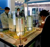 Visitors look at models of residential towers of a real estate development project during the Vietbuild 2011