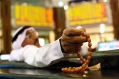 An investor sits holding his prayer beads while monitoring stock prices at the Dubai Financial Market in Dubai, United Arab Emirates, on Wednesday, Feb. 2, 2011. 