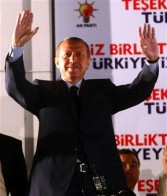 Turkish Prime Minister Tayyip Erdogan greets his supporters as they wave flags outside of the Justice and Development Party (AKP) headquarters in Ankara on June 12, 2011.