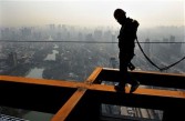 A Chinese worker makes his way along a beam at a construction project in Hefei, east China's Anhui province on April 14, 2011.