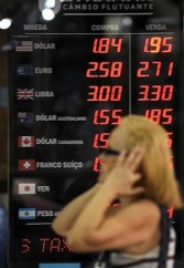 Brazilian woman looks at currency exchange bureau board in Rio de Janiero