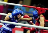 Dong Cheng of China (R) competes with Tassamalee Thongjan of Thailand during the women's 57-60kg boxing final competition at the 16th Asian Games in Guangzhou on November 26, 2010.