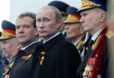 Russian President Dmitry Medvedev (L), Prime Minister Vladimir Putin (2nd L) and WW II veterans watch a military parade during the nation's Victory Day celebrations in Moscow on May 9, 2011