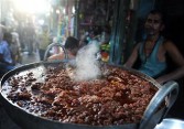 An Indian street vendor prepares a traditional dish at a roadside shop