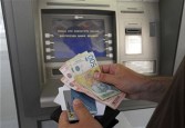 Serbian customer takes money from an ATM in Belgrade