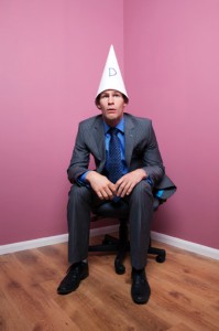 a man in a business suit with dunce cap