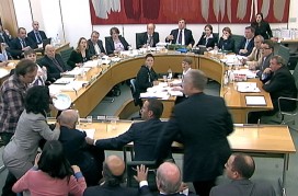 A man tries to attack News Corp Chief Executive and Chairman Rupert Murdoch with a white substance during a parliamentary committee hearing on phone hacking at Portcullis House in London