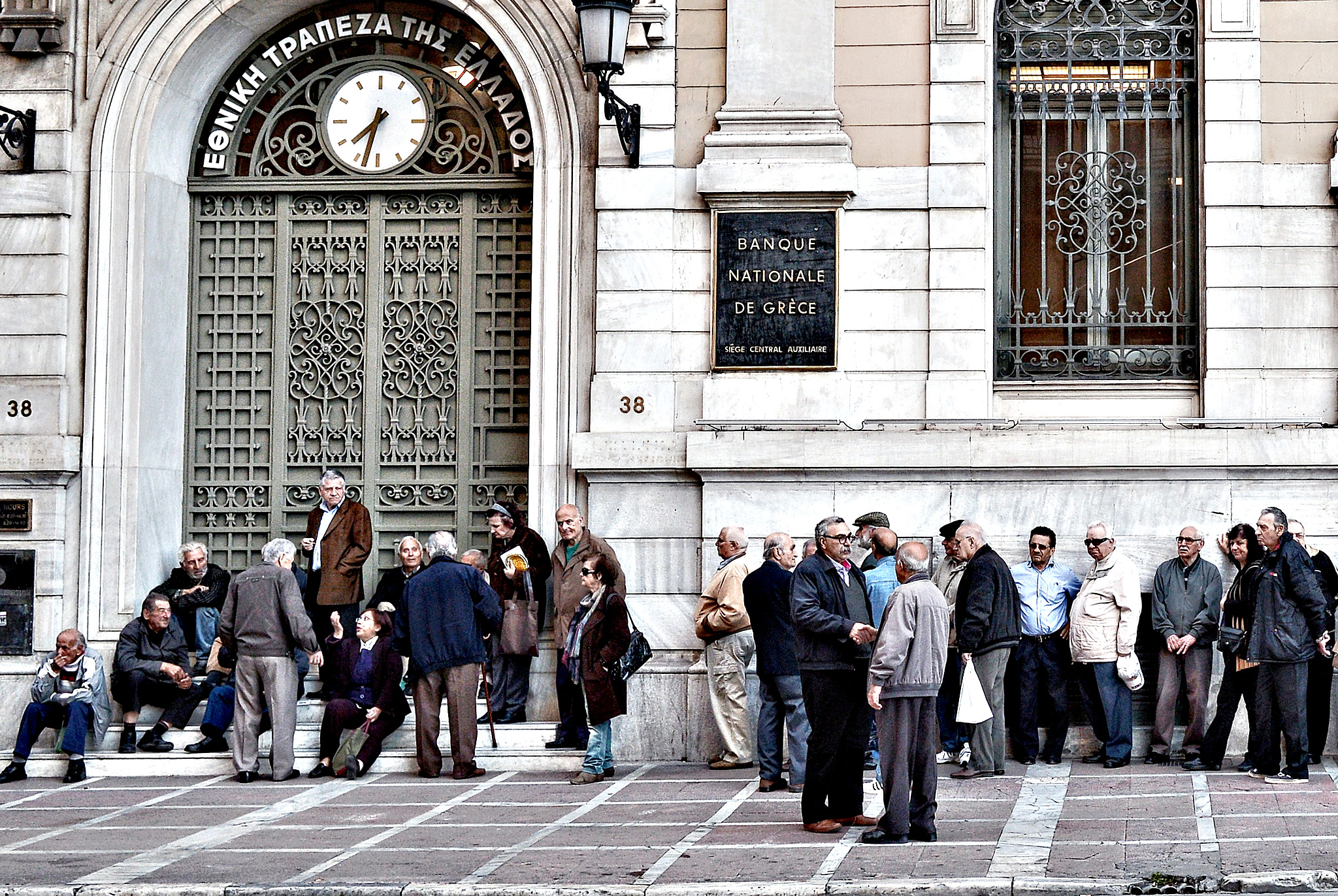 Pensioners wait outside the National Bank of Greece to get their monthly pensions on April 29, 2015. Greece has been trying to negotiate a deal that would unlock 7.2 billion euros (7.8 billion USD) in remaining EU-International Monetary Fund bailout money that the debt-ridden Mediterranean country needs to avoid default and a possible exit from the euro. So far, Athens has resisted new pension caps, the elimination of some VAT exemptions and no longer wants to use privatisation proceeds to repay state debt