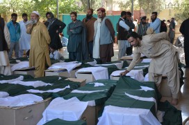 Mourners gather round the coffins of victims of the attack on a military academy in Quetta, Baluchistan
