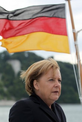 Angela Merkel stands next to a German flag. Photo: Sean Gallup / Getty Images